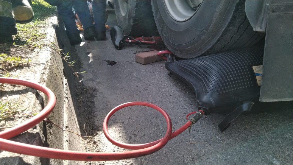 Bombeiros usaram uma almofada pneumática para elevar o eixo do caminhão  — Foto: Corpo de Bombeiros/Divulgação