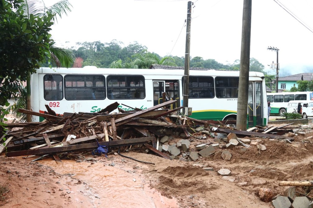 Carros e ônibus tiveram que ser retirados com ajuda de tratores da prefeitura depois de enxurrada em Guabiruba (SC) — Foto: Luiz Carlos Souza/NSC TV