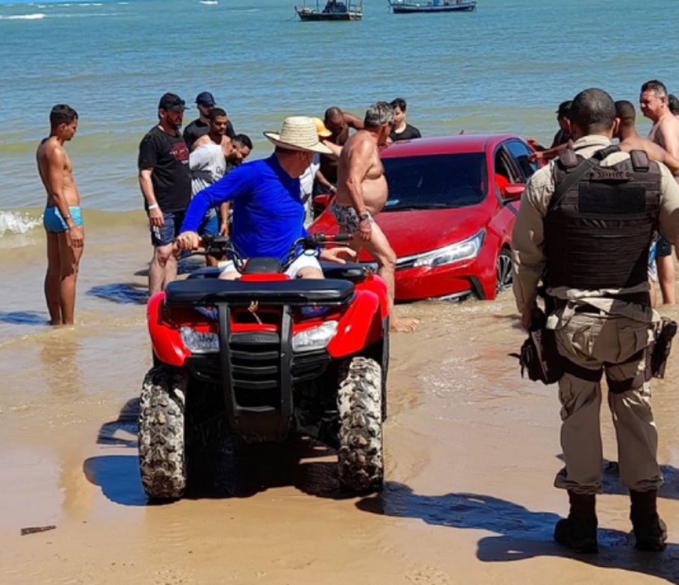 Carro atola em praia de Guarajuba e é retirado do mar com ajuda de banhistas e viatura da PM — Foto: Alex Soares/Arquivo Pessoal