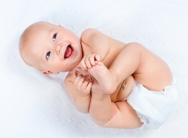 Bebê segura os pés (Foto: ThinkStock)