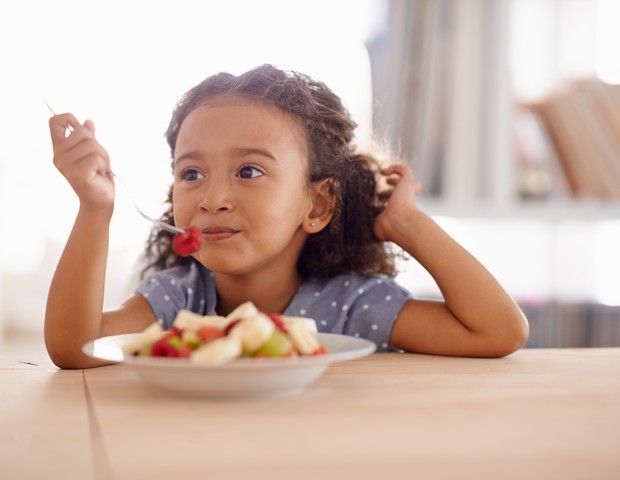 Garota comendo frutas (Foto: Getty Images)