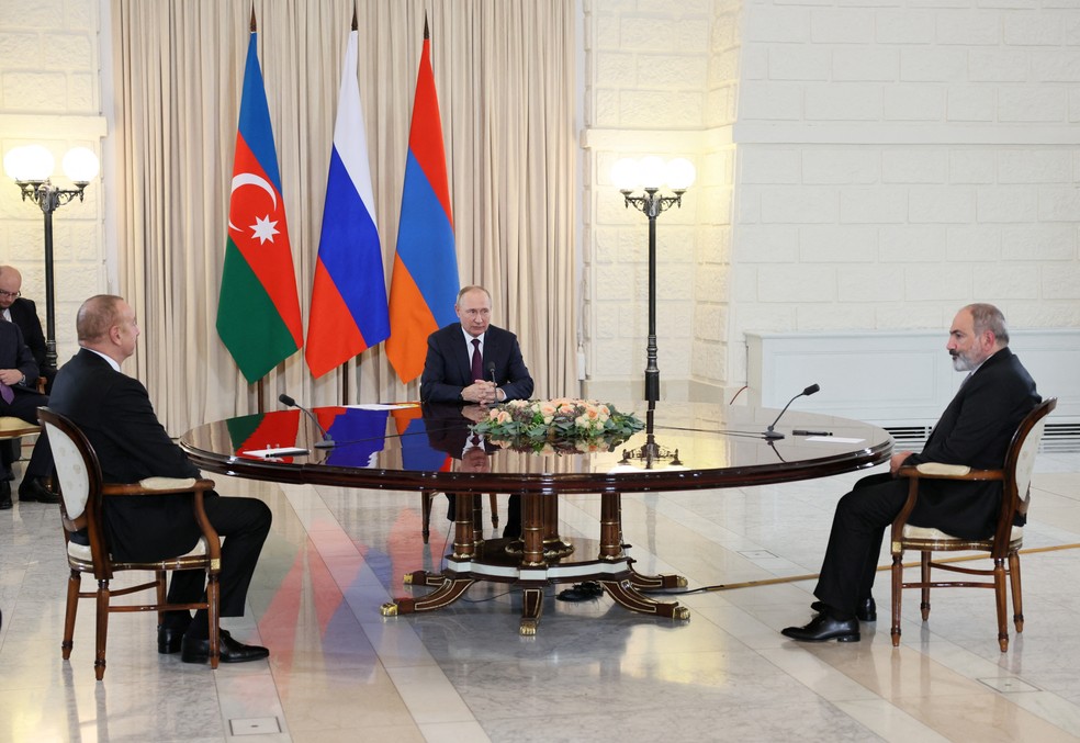 O presidente da Rússia, Vladimir Putin, o primeiro-ministro da Armênia, Nikol Pashinyan, e o presidente do Azerbaijão, Ilham Aliyev, participam de uma reunião trilateral em Sochi — Foto: Sergey Bobylev/Sputnik/via REUTERS