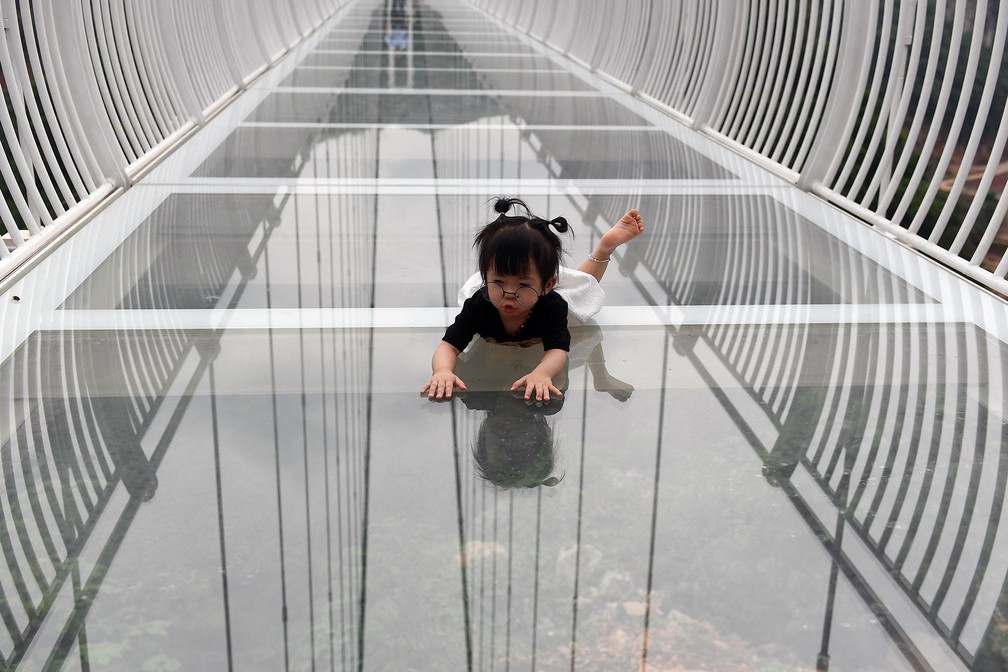 Criança na ponte de vidro Bach Long, suspensa entre duas montanhas no distrito de Moc Chau, província de Son La — Foto: Nhac Nguyen/AFP