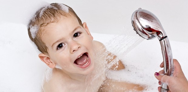 Criança sorrindo e tomando banho (Foto: Shutterstock)