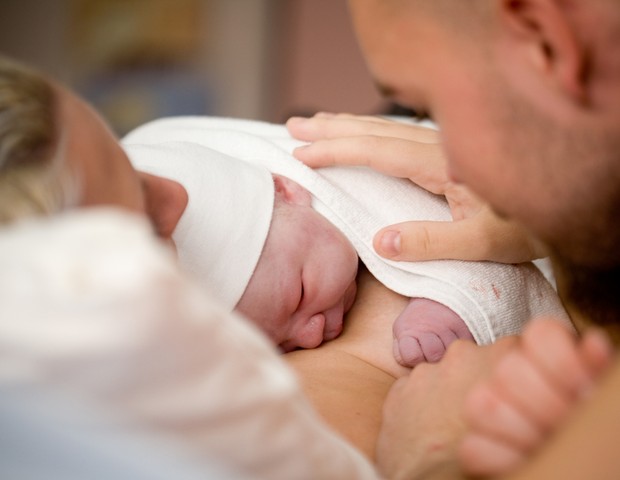 Bebê no colo dos pais na maternidade (Foto: Shutterstock)