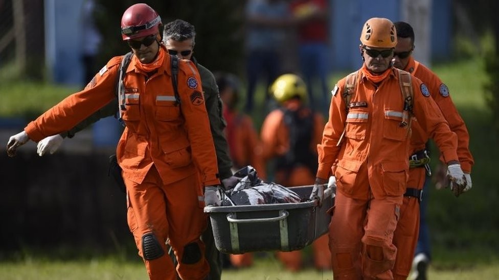 Bombeiros carregam corpo encontrado em Brumadinho (Foto: AFP via BBC)