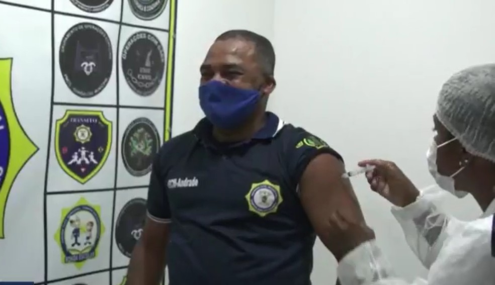 Agentes da Guarda Civil de Campos, RJ, começaram a ser imunizados na terça-feira (30); Clécio Andrade se emocionou ao receber a dose — Foto: Reprodução/Inter TV