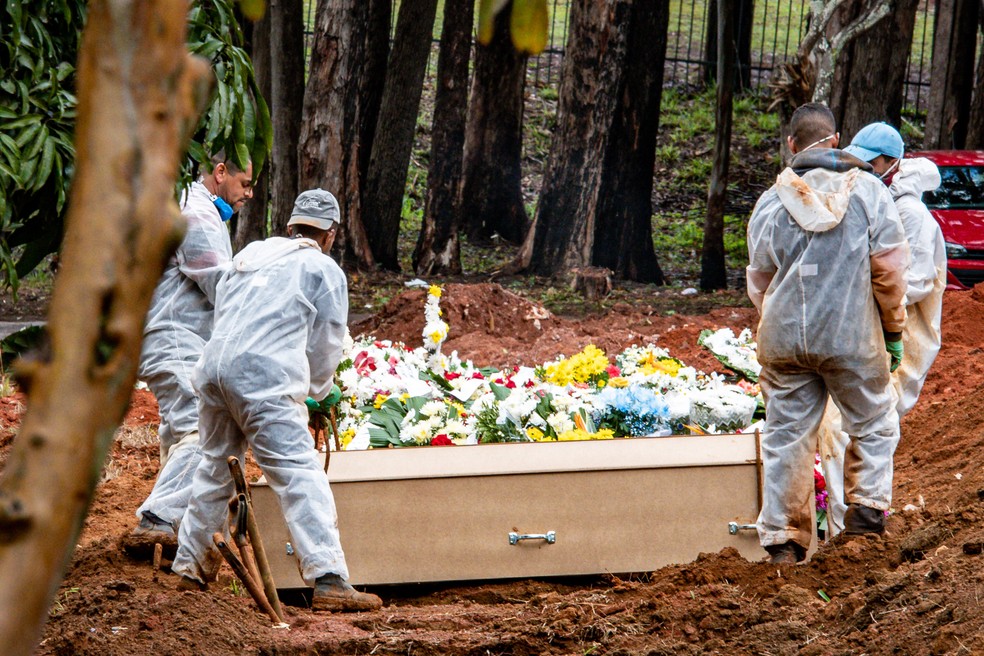  Movimentação de funcionários e pequenos grupos familiares no sepultamento de se seus entes no Cemitério da Vila Formosa, na zona leste da cidade de São Paulo, que abriu novas covas para vítimas da Covid-19, na manhã de 22 de agosto de 2020. — Foto: ANTONIO MOLINA/ZIMEL PRESS/ESTADÃO CONTEÚDO 