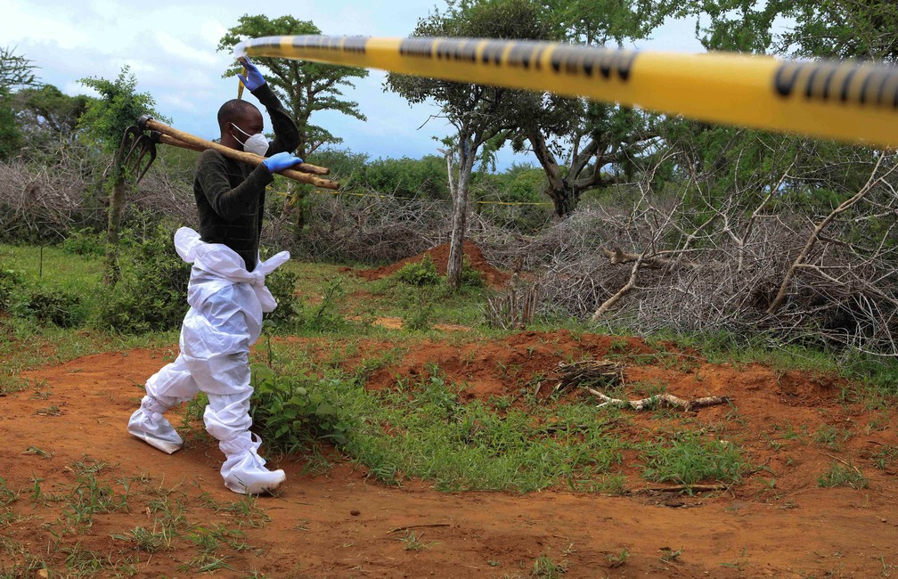 Investigador entra em área isolada para exumar corpos de supostos membros de seita cristã no Quênia que pregava jejum — Foto: Stringer/Reuters