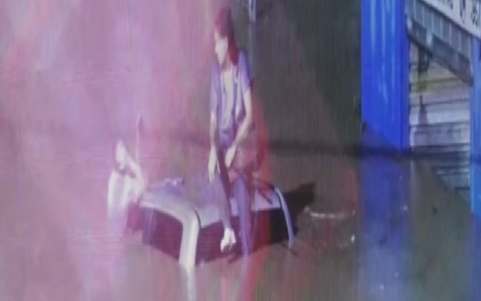Mulher é resgatada do teto de carro após forte chuva — Foto: Reprodução/TV Anhanguera