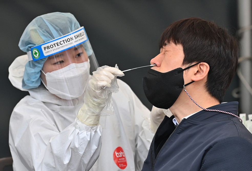 Profissional de saúde faz teste PCR para identificar se sul-coreano está com Covid-19 em centro de testagem de Seul, capital da Coreia do Sul, no dia 17 de março de 2022 — Foto: Jung Yeon-je/AFP