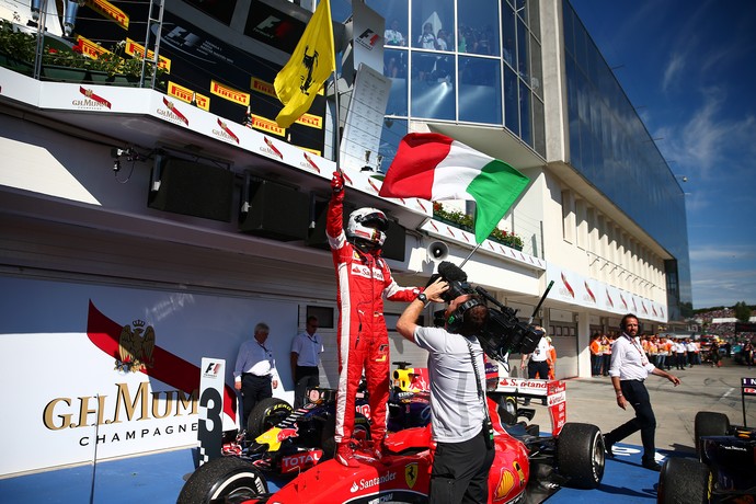 Sebastian Vettel com as bandeiras da Ferrari e da Itália após vitória no GP da Hungria de Fórmula 1 2015 (Foto: Getty Images)