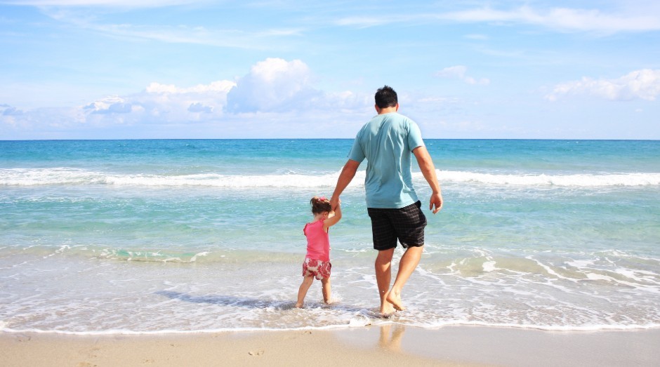 Pai e filha caminham em praia; férias (Foto: Pixabay/Reprodução)