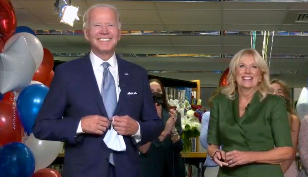 Joe Biden, acompanhado da esposa Jill Biden, comemora a indicação como candidato a presidência no segundo dia da Convenção Nacional Democrata, nos EUA, nesta terça (18)  — Foto: Convenção Nacional Democrata / Pool / Reuters