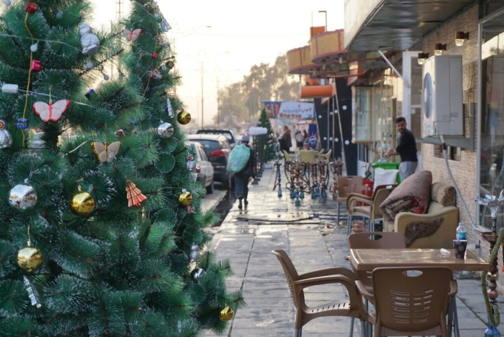 Árvore de Natal decorada na calçada em frente a uma lanchonete da parte leste de Mossul, que faz parte de uma série de fotografias do professor e fotógrafo Ali Al-Baroodi para documentar a vida na cidade após o Estado Islâmico (Foto: Arquivo pessoal/Ali Al-Baroodi)