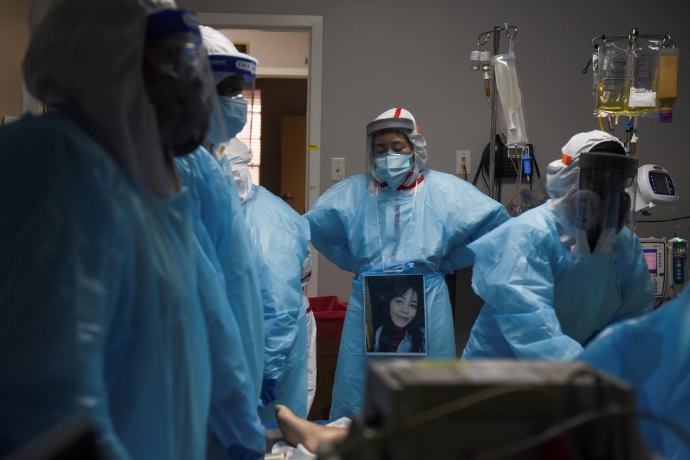 Foto de 12 de dezembro de 2020 mostra profissionais de saúde em volta de paciente que morreu no setor de Covid-19 de hospital em Houston, no Texas — Foto: Callaghan O'Hare/Reuters