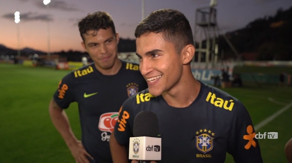 Thiago Silva observa Rodrigo Nestor dando entrevista durante período de treinos na Seleção — Foto: Reprodução / CBF TV