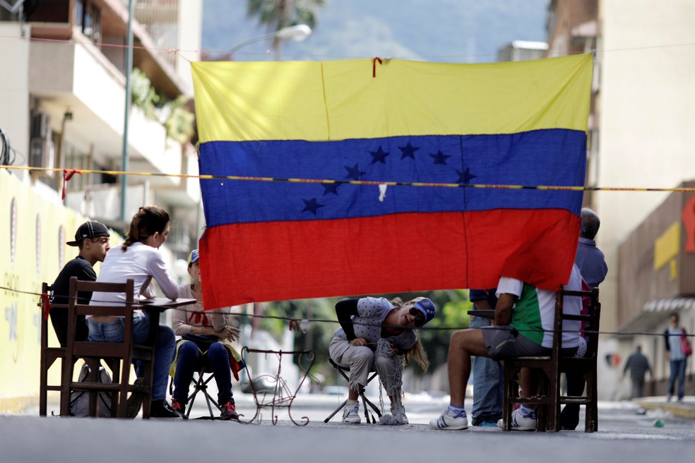Venezuelanos são vistos atrás de barricada em Caracas (Foto: REUTERS/Ueslei Marcelino)