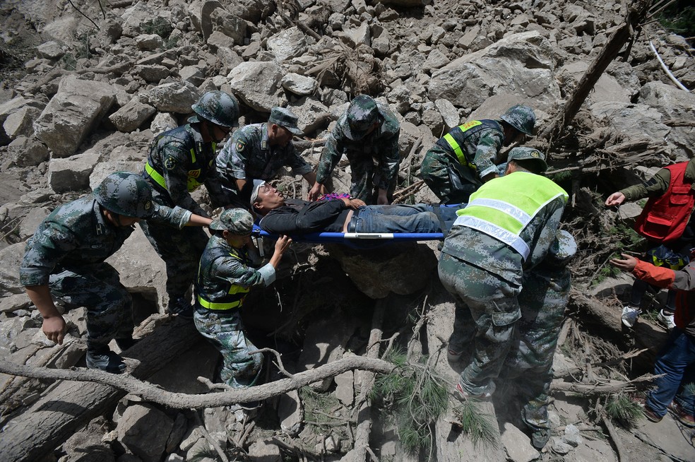 Equipes de resgate carregam sobrevivente de terremoto na China (Foto: Chengdu Economic Daily/Wang Qin via REUTERS)