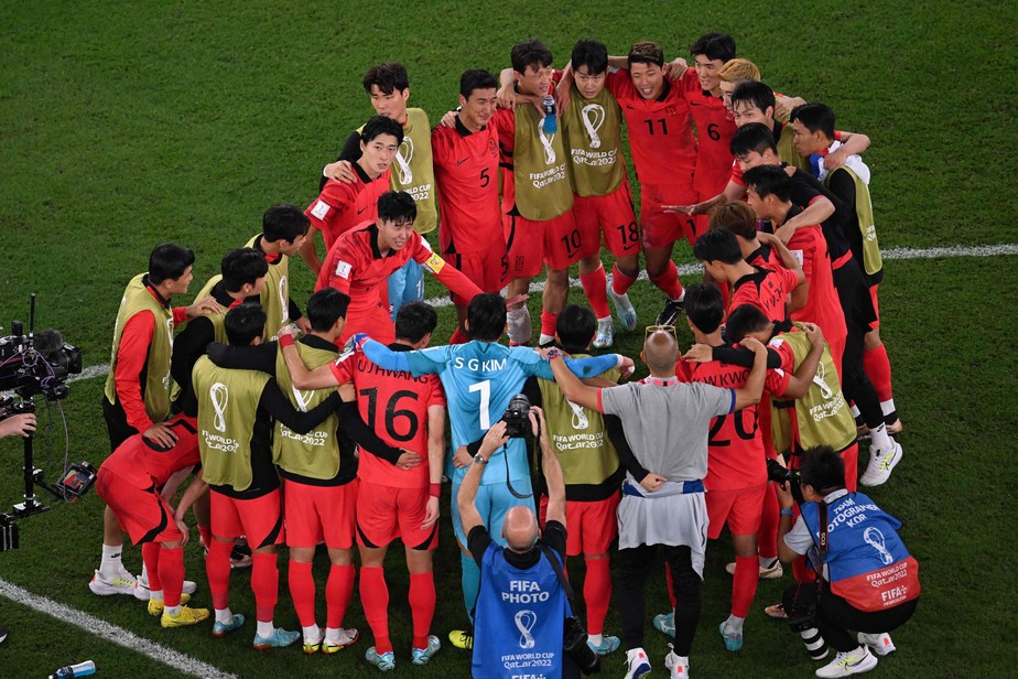 Jogadores da Coreia do Sul aguardam, em campo, o fim da partida entre Uruguai x Gana, após terem vencido Portugal, antes de comemorar classificação
