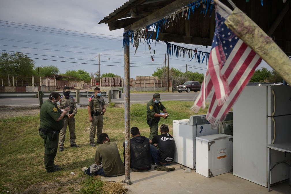 Policiais detêm grupo que tentou cruzar a fronteira EUA-México em 27 de março em Roma (Texas) — Foto: Ed Jones/AFP