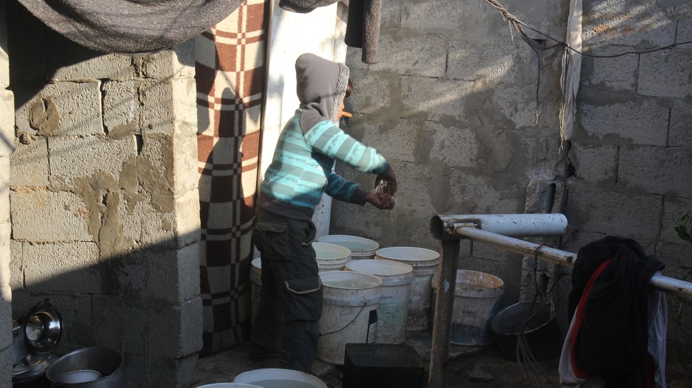Criança da família Zyara enquanto pega água para beber — Foto: Eman Jomaa/Dollar Street
