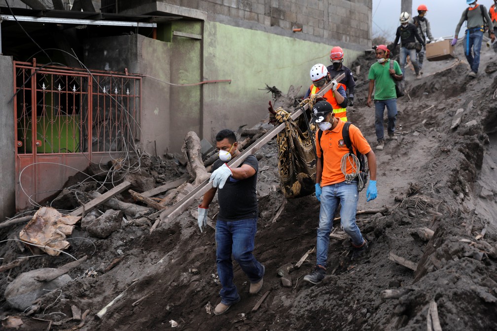 VoluntÃ¡rios carregam restos mortais em Escuintla, cidade atingida pelas cinzas do VulcÃ£o de fogo, na Guatemala (Foto: Carlos Jasso/Reuters)
