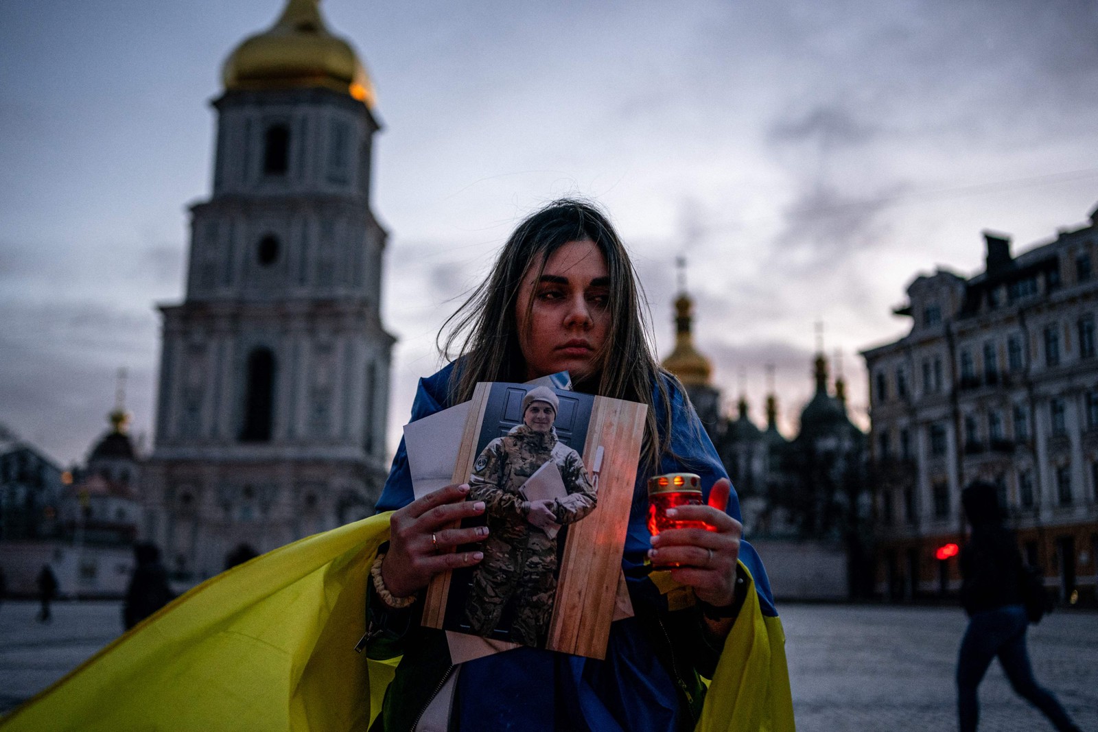 Mulher ucraniana segura uma vela e um retrato de seu marido que foi capturado durante o cerco à cidade portuária de Mariupol — Foto: DIMITAR DILKOFF/AFP