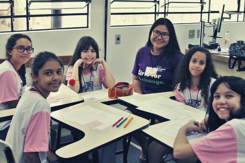 mentora e alunas sorriem para foto no evento