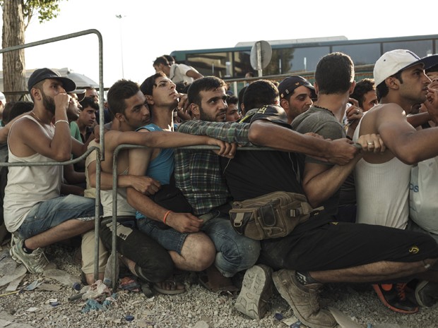 Imigrantes aguardam para se registrarem perante as autoridades de Mytilene, na ilha grega de Lesbos, na segunda (17) (Foto: AFP Photo/Achilleas Zavallis)