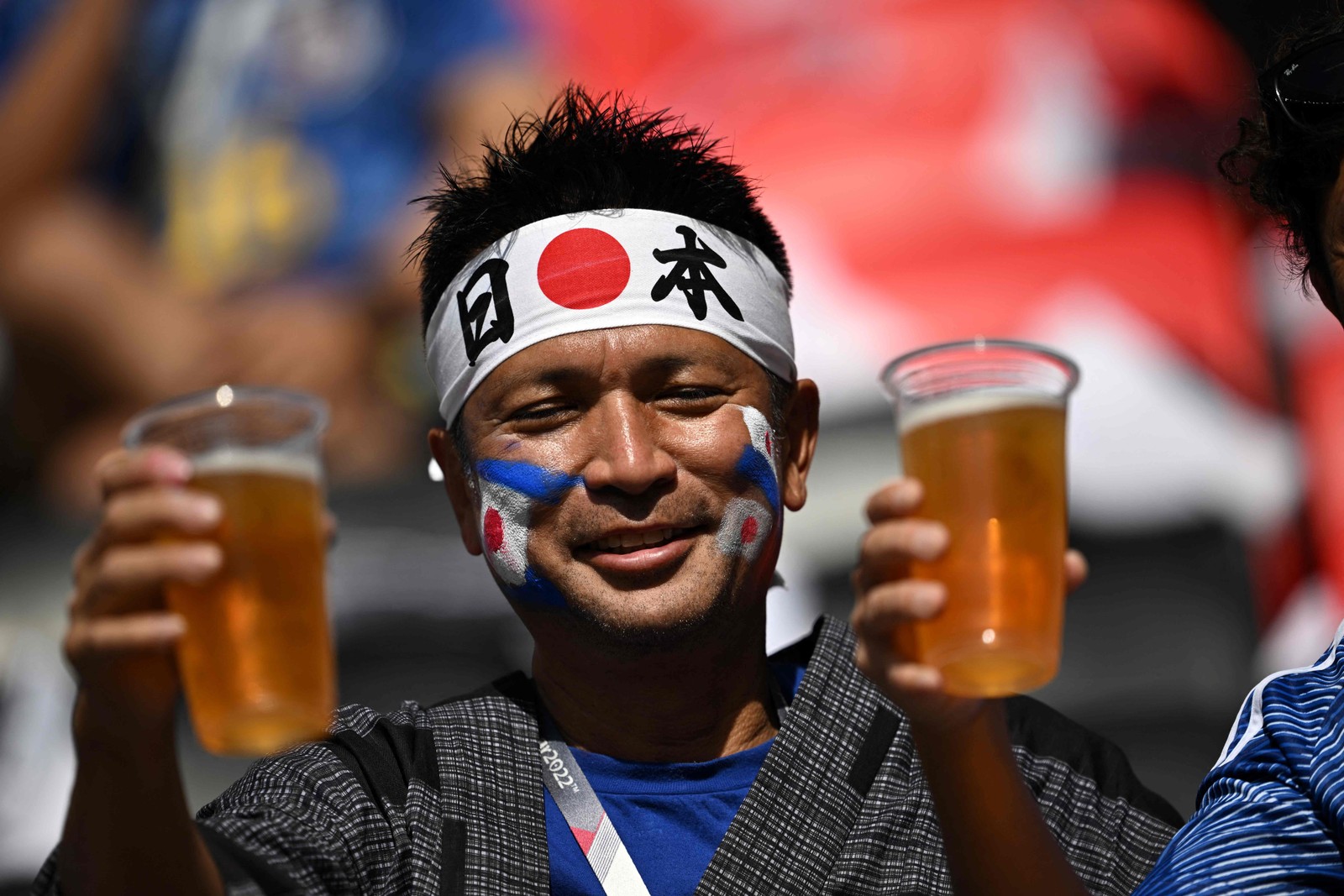 Torcedores japoneses exibem cerveja sem álcool no Estádio Ahmad Bin Ali  — Foto: ANNE-CHRISTINE POUJOULAT/AFP