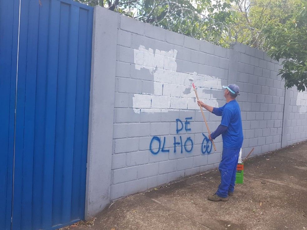 Funcionários tentam limpar muros da Toca da Raposa que foram pichados — Foto: Diogo Finelli / Globoesporte.com