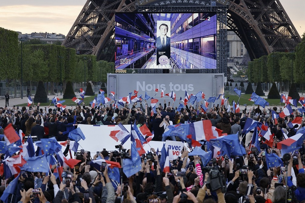 Público reunido no Champ de Mars, em Paris, reage após projeções apontarem vitória de Macron na França — Foto: Ludovic MARIN / AFP