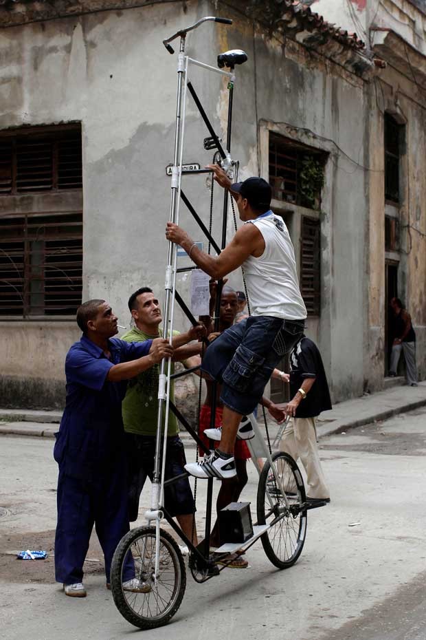 Felix Guirola precisa de ajuda para subir na bicicleta. (Foto: Franklin Reyes/AP)