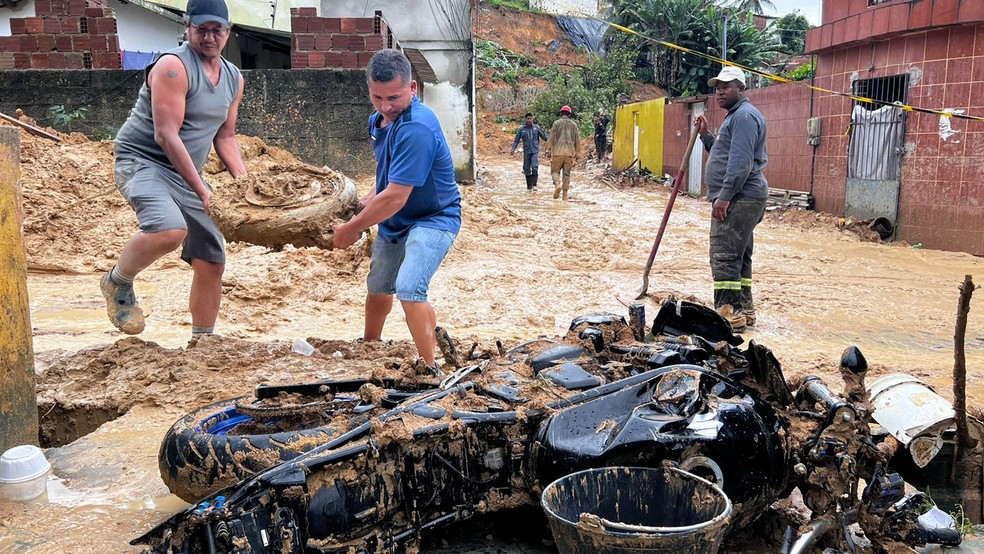 Moradores recuperaM pertences em meio à lama, em Jardim Monte Verde, no Recife — Foto: Mhatteus Sampaio/TV Globo