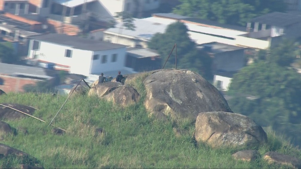 Imagens do Globocop mostram criminosos monitorando a movimentação na Vila Aliança do alto de um morro na região — Foto: Reprodução / TV globo