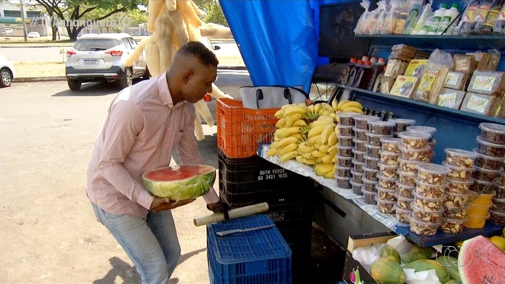 Hiaggo Henrique ainda usa o carro incendiado para vender os produtos — Foto: TV Anhanguera/Reprodução