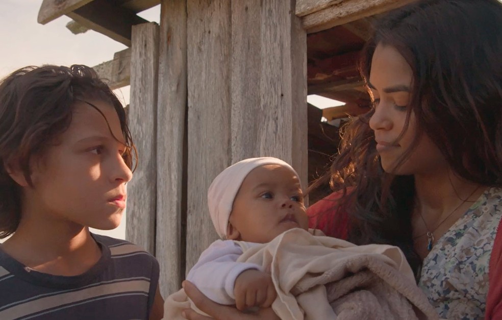 Em 'Amor de Mãe', Lurdes (Lucy Alves) encontra uma bebê abandonada e a cria como filha — Foto: Globo
