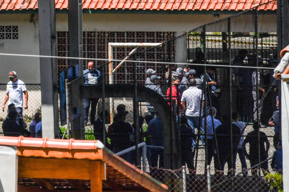 Familiares e amigos aguardam por informações na entrada da  Escola Estadual Raul Brasil em Suzano, na Grande São Paulo. Dois adolescentes encapuzados mataram oito pessoas no local e cometeram suicídio em seguida  — Foto: Nelson Almeida/AFP