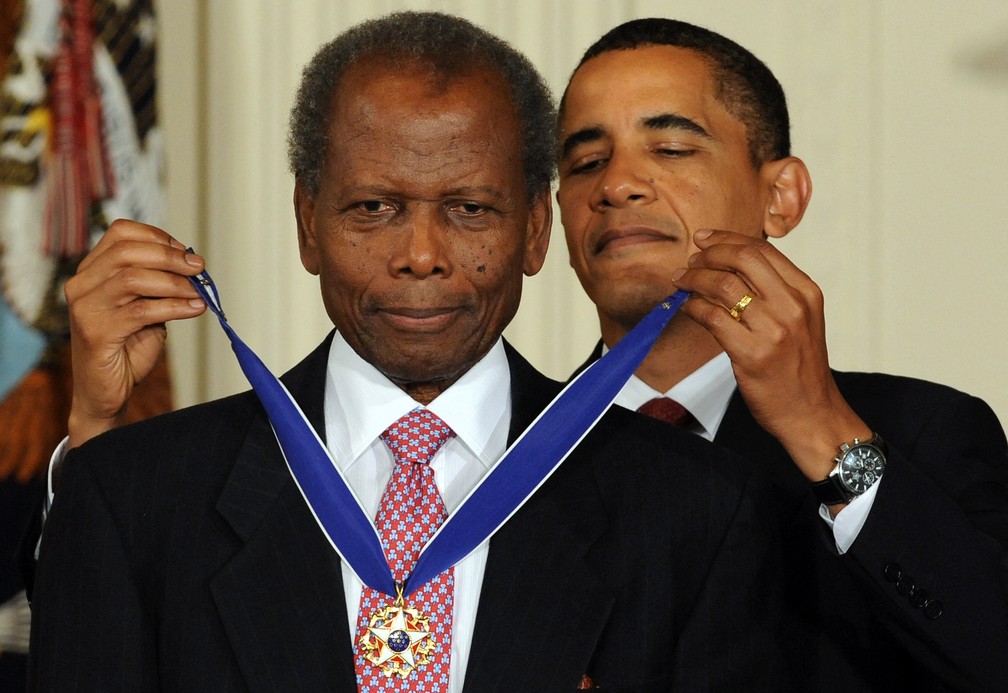 Em agosto de 2009, o então presidente Barack Obama concede medalha presidencial ao ator Sidney Poitier — Foto: Jewel SAMAD / AFP