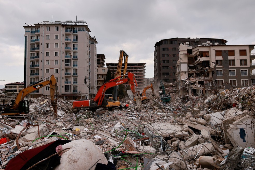 Tratores limpam destroços de prédios derrubados por terremotos em Antáquia, na Turquia — Foto: Thaier Al-Sudani/REUTERS