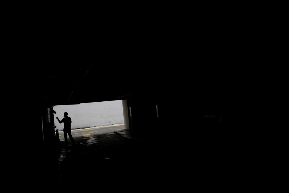 Homem caminha em garagem em Caracas em dia de blecaute na Venezuela — Foto: Carlos Garcia Rawlins/Reuters