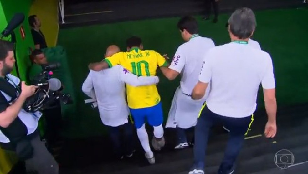 Neymar deixa o jogo amparado pela comissão técnica — Foto: Reprodução de TV