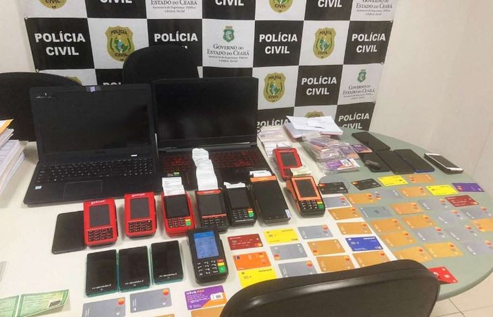 Polícia apreendeu 54 cartões em nomes de terceiros, maquinetas e outros equipamentos no quarto onde o preso por estelionato estava hospedado em Fortaleza. — Foto: Polícia Civil/ Divulgação