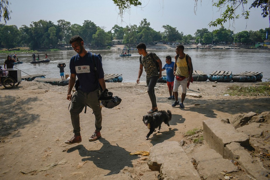 Imigrantes venezuelanos caminham depois de cruzar em uma jangada improvisada o rio Suchiate em Ciudad Hidalgo, no México, na fronteira com Tecun Uman, na Guatemala