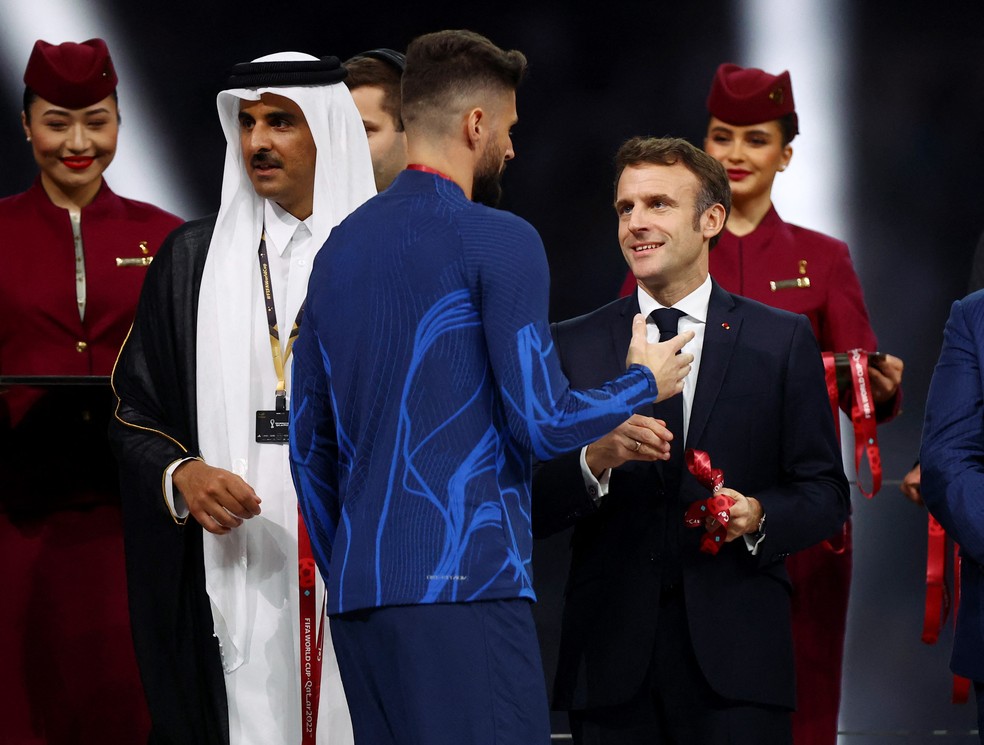 Emmanuel Macron entrega medalha de segundo lugar ao jogador francês Olivier Giroud — Foto: Hannah Mckay/Reuters 