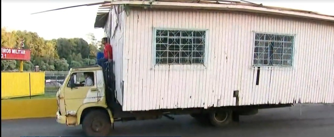 Caminhão transporta casa de madeira com homem no teto do veículo em SC; VÍDEO