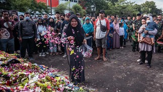 Mulher presta homenagem aos 125 que morreram pisoteados no estádio Kanjuruhan em Malang, Java Oriental — Foto: JUNI KRISWANTO/AFP