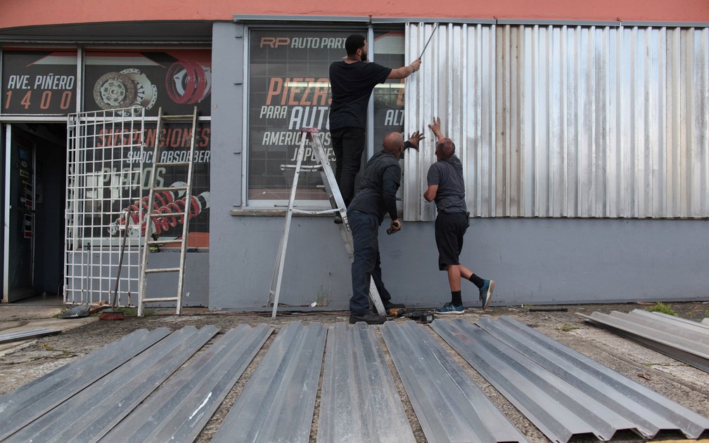 Funcionários colocam placas para proteger janelas de oficina em San Juan, Porto Rico, antes da passagem do furacão Irma, na terça (5) (Foto: Reuters/Alvin Baez)