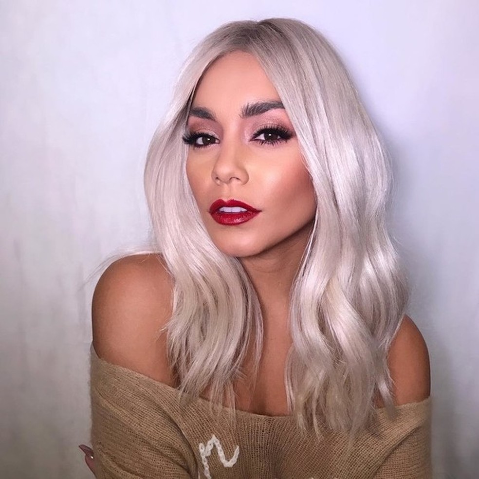 mulher com cabelo longo platinado e maquiagem com olhos marcantes e boca vermelha